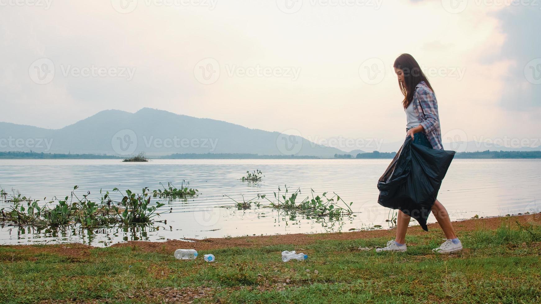 Happy young Asia activists collecting plastic waste on the beach. Korean lady volunteers help to keep nature clean up and pick up garbage. Concept about environmental conservation pollution problems. photo