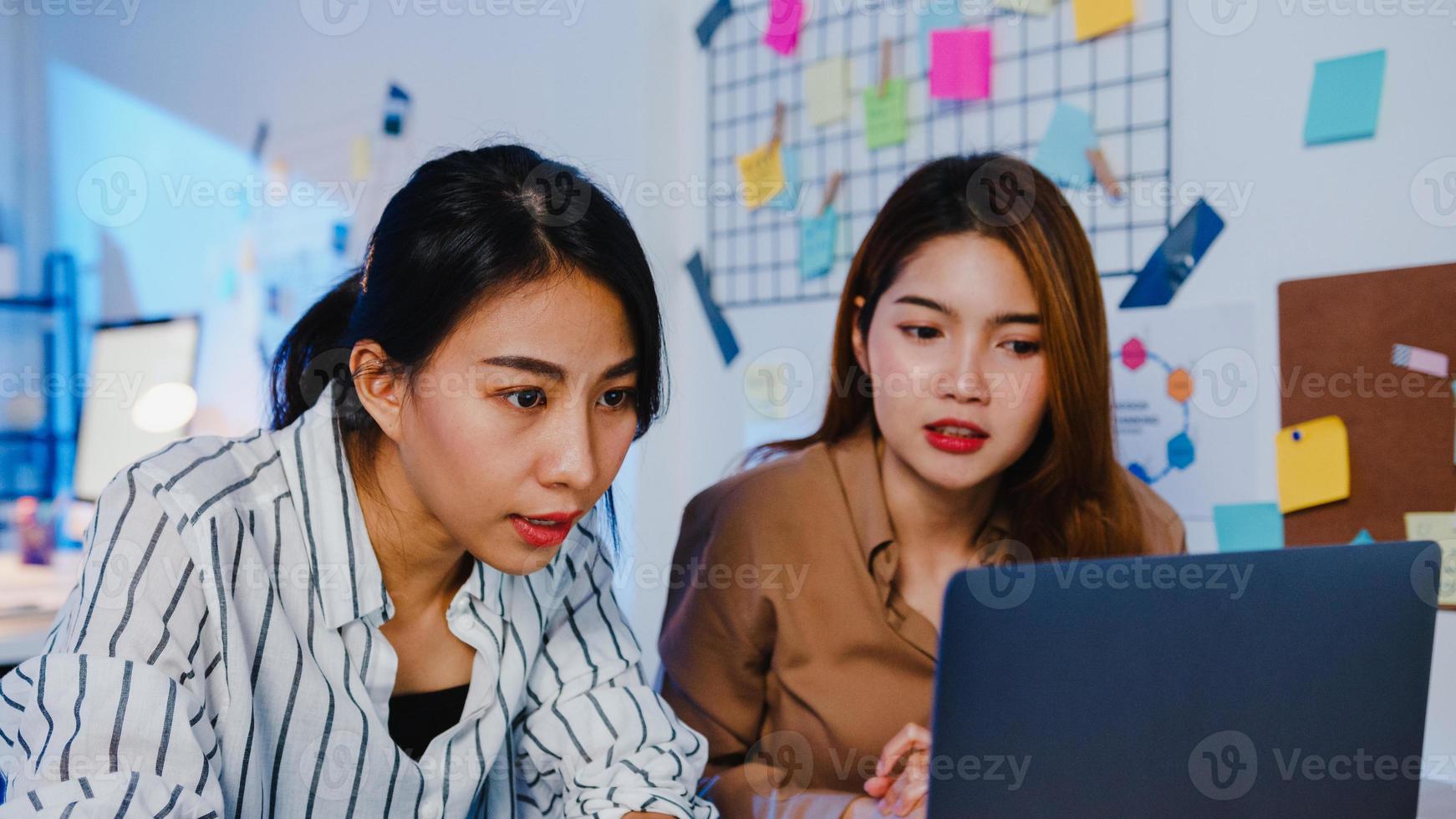 grupo de empresarios asiáticos que utilizan la computadora portátil reunión de presentación y comunicación de intercambio de ideas sobre nuevos colegas del proyecto plan de trabajo estrategia de éxito en la noche moderna oficina en casa. foto