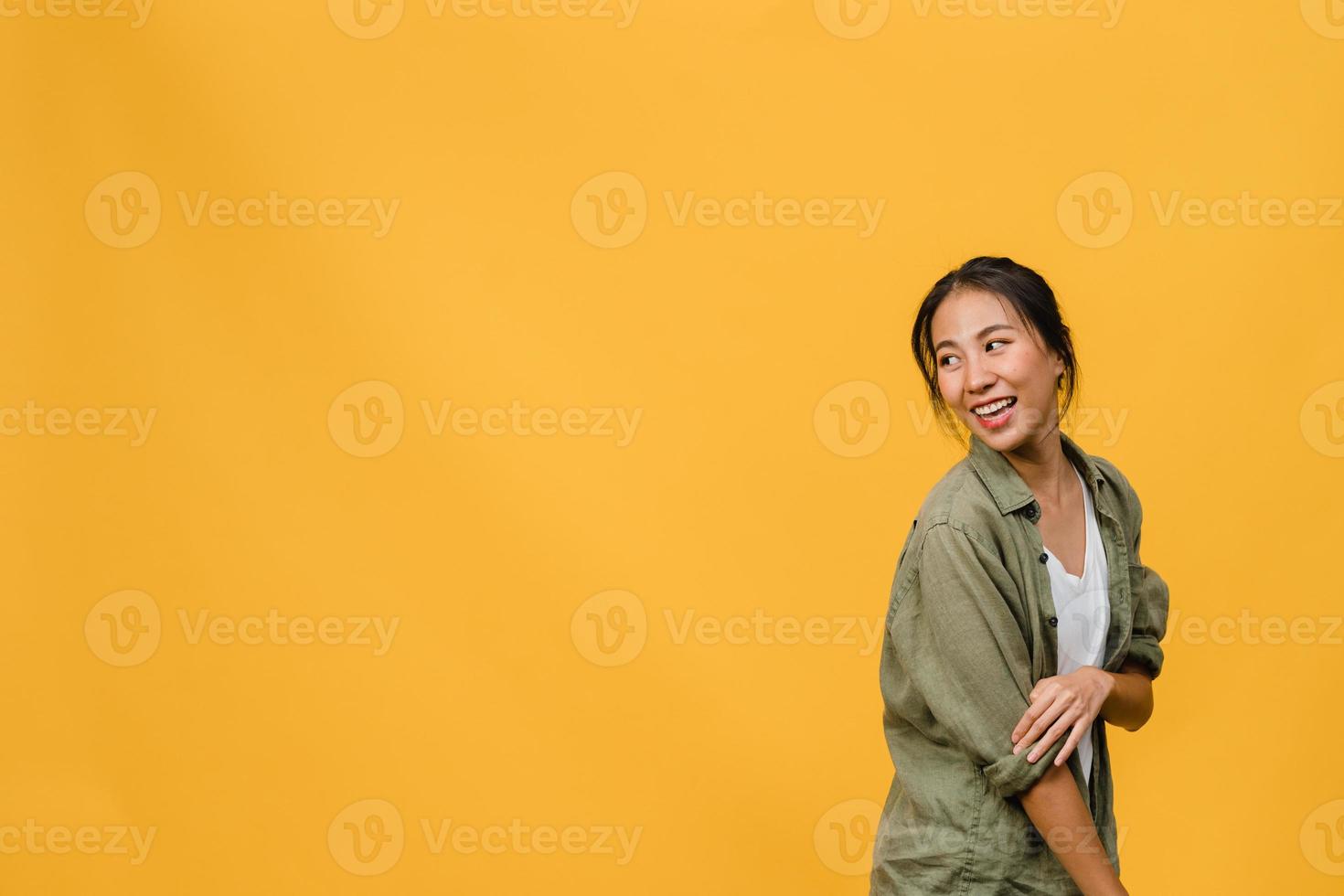 Retrato de joven asiática con expresión positiva, sonrisa amplia, vestida con ropa casual sobre fondo amarillo. feliz adorable mujer alegre se regocija con el éxito. concepto de expresión facial. foto