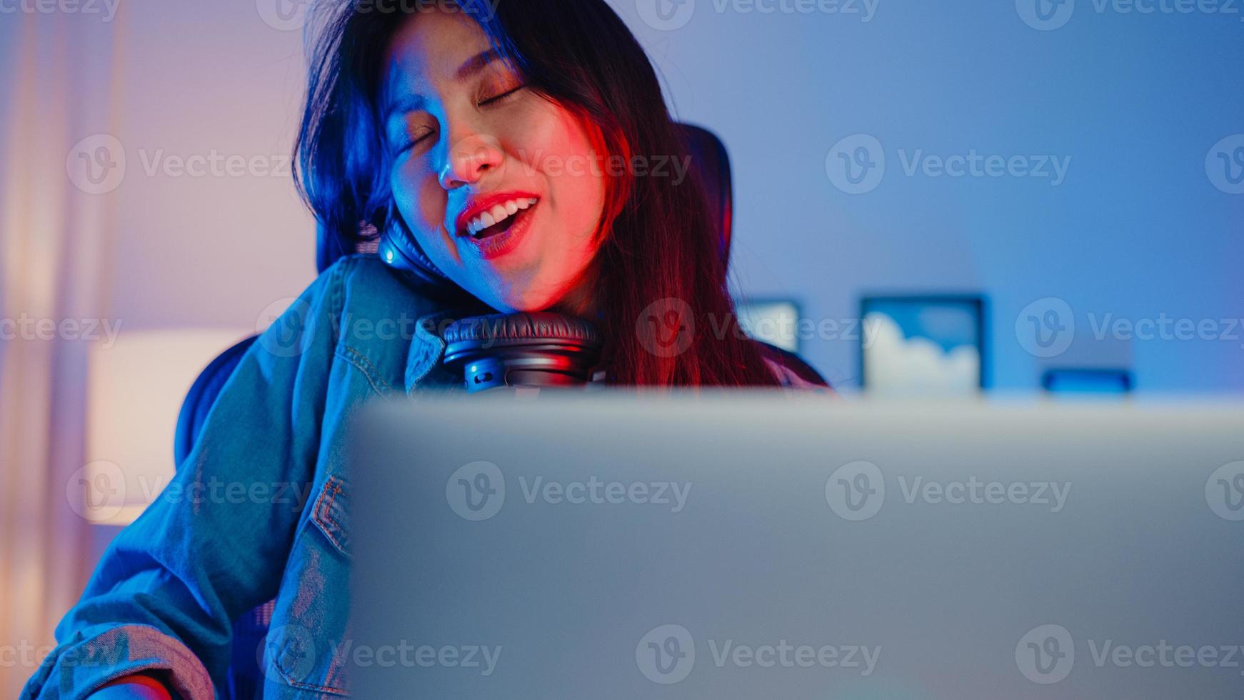 blogger de niña asiática feliz jugar teclado sintetizador usar auriculares y grabar música con mezclador de sonido en la computadora portátil en el estudio de la sala de estar por la noche. creador de contenido musical, tutorial, concepto de transmisión. foto