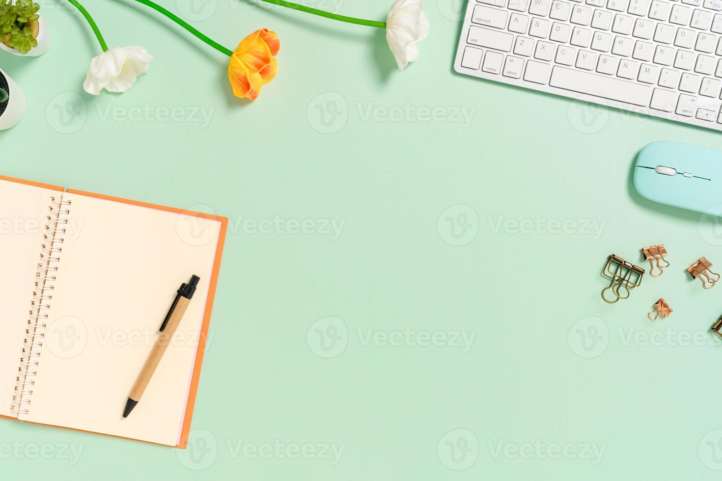 Foto creativa plana del escritorio del espacio de trabajo. escritorio de oficina de vista superior con teclado, mouse y cuaderno negro de maqueta abierta sobre fondo de color verde pastel. vista superior maqueta con fotografía de espacio de copia.