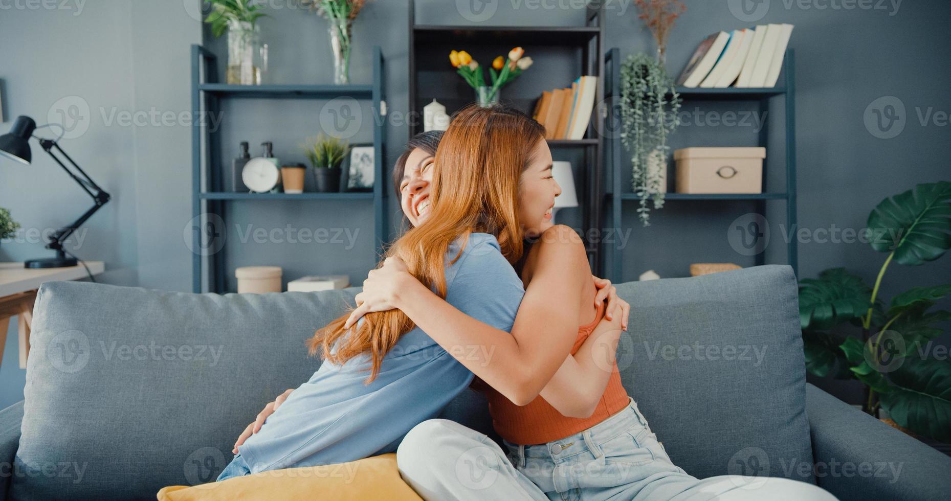 Happy Asian women teenager visit her close friends cuddling smiling at home. Overjoyed excited best buddies embracing hugging, greeting each other with success, true strong friendship concept. photo