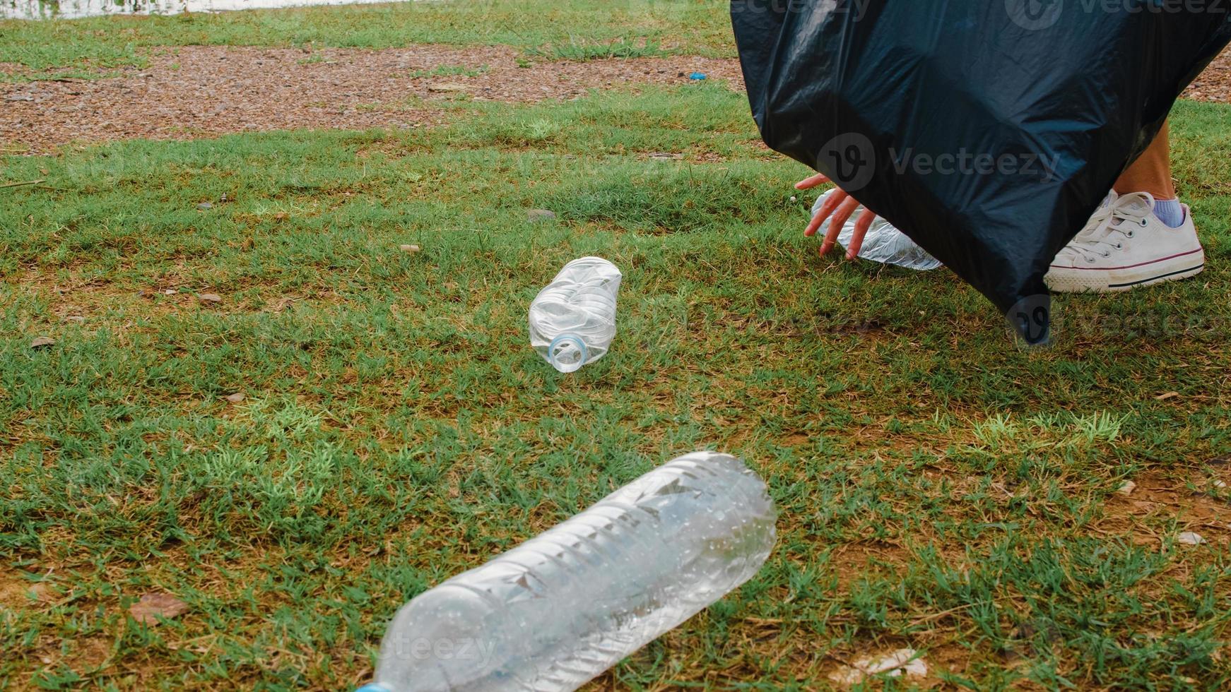 Happy young Asia activists collecting plastic waste on the beach. Korean lady volunteers help to keep nature clean up and pick up garbage. Concept about environmental conservation pollution problems. photo