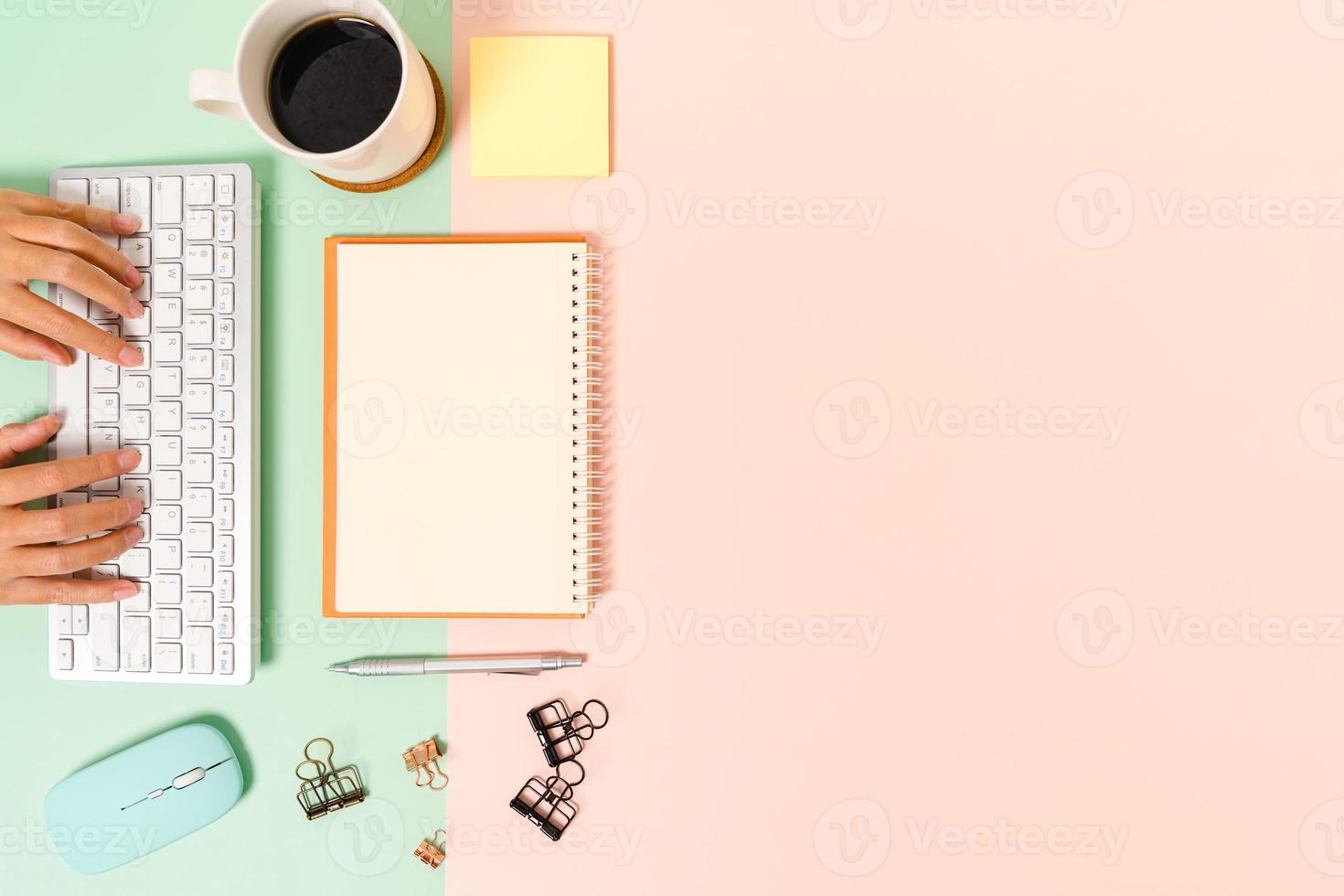 Creative flat lay photo of workspace desk. Top view office desk with keyboard, mouse and open mockup black notebook on pastel green pink color background. Top view mock up with copy space photography.