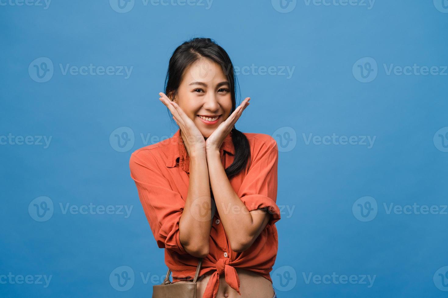 Young Asia lady with positive expression, smile broadly, dressed in casual clothing and looking at camera over blue background. Happy adorable glad woman rejoices success. Facial expression concept. photo