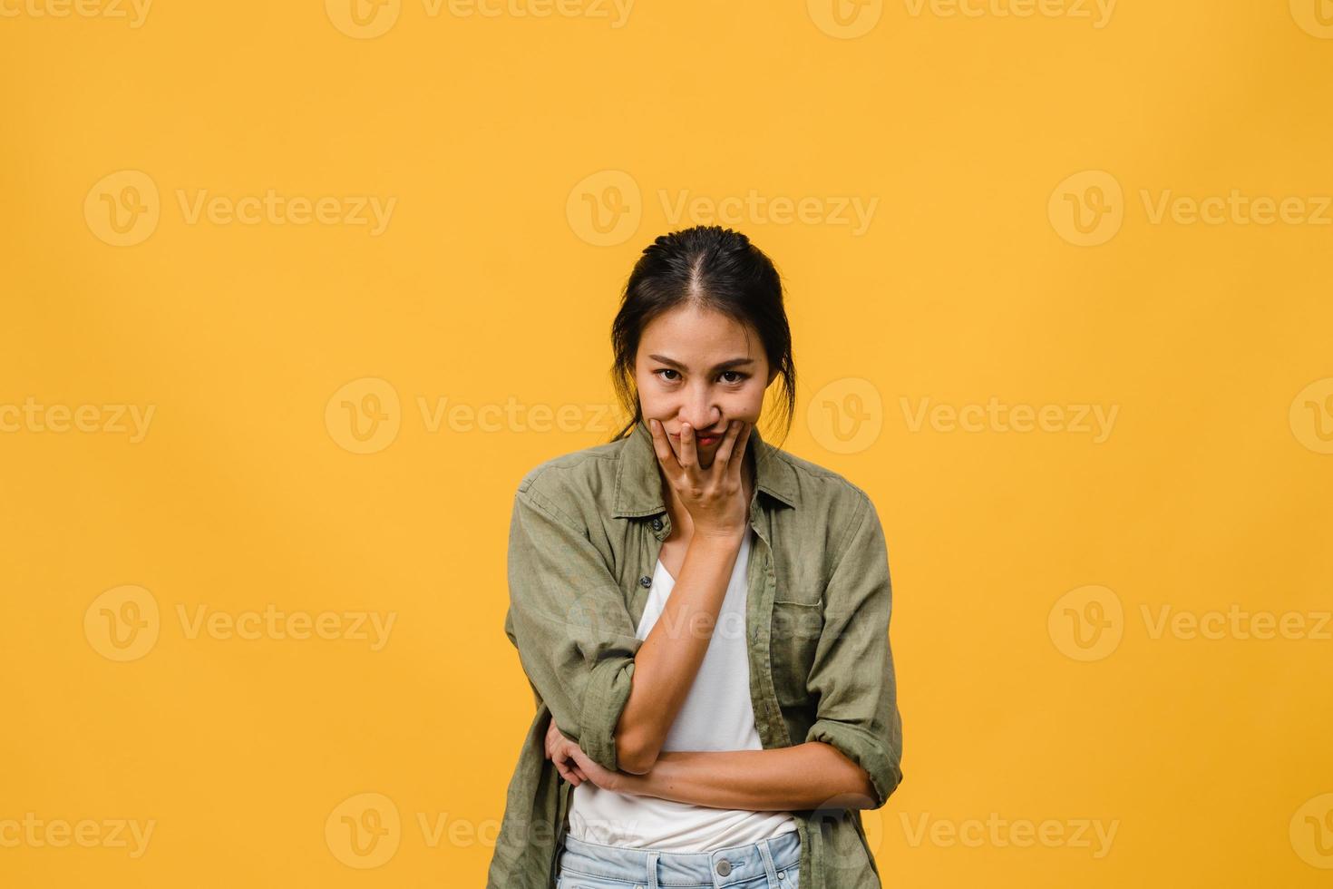 Young Asia lady with negative expression, excited screaming, crying emotional angry in casual clothing and look at camera isolated on yellow background with blank copy space. Facial expression concept photo