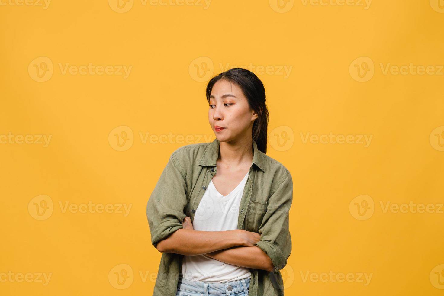 Retrato de joven asiática con expresión negativa, gritos emocionados, llorando emocionalmente enojado en ropa casual aislado sobre fondo amarillo con espacio de copia en blanco. concepto de expresión facial. foto