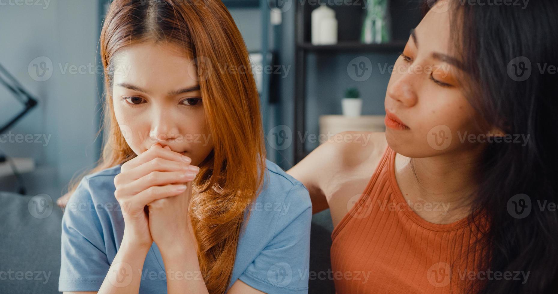 Asian women teenager embracing to calm her sad best friends from feeling down from breakup with boyfriend in living room at home. Friendship counseling and care, unhappy girl support her girlfriend. photo