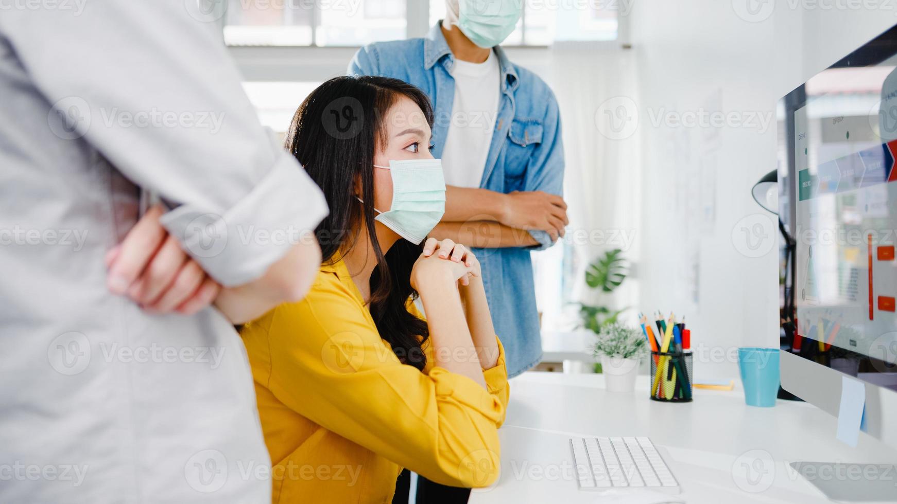 Empresarios asiáticos que usan reuniones de presentación por computadora para intercambiar ideas sobre nuevos colegas de proyectos y usan una mascarilla protectora en la nueva oficina normal. estilo de vida y trabajo después del coronavirus. foto