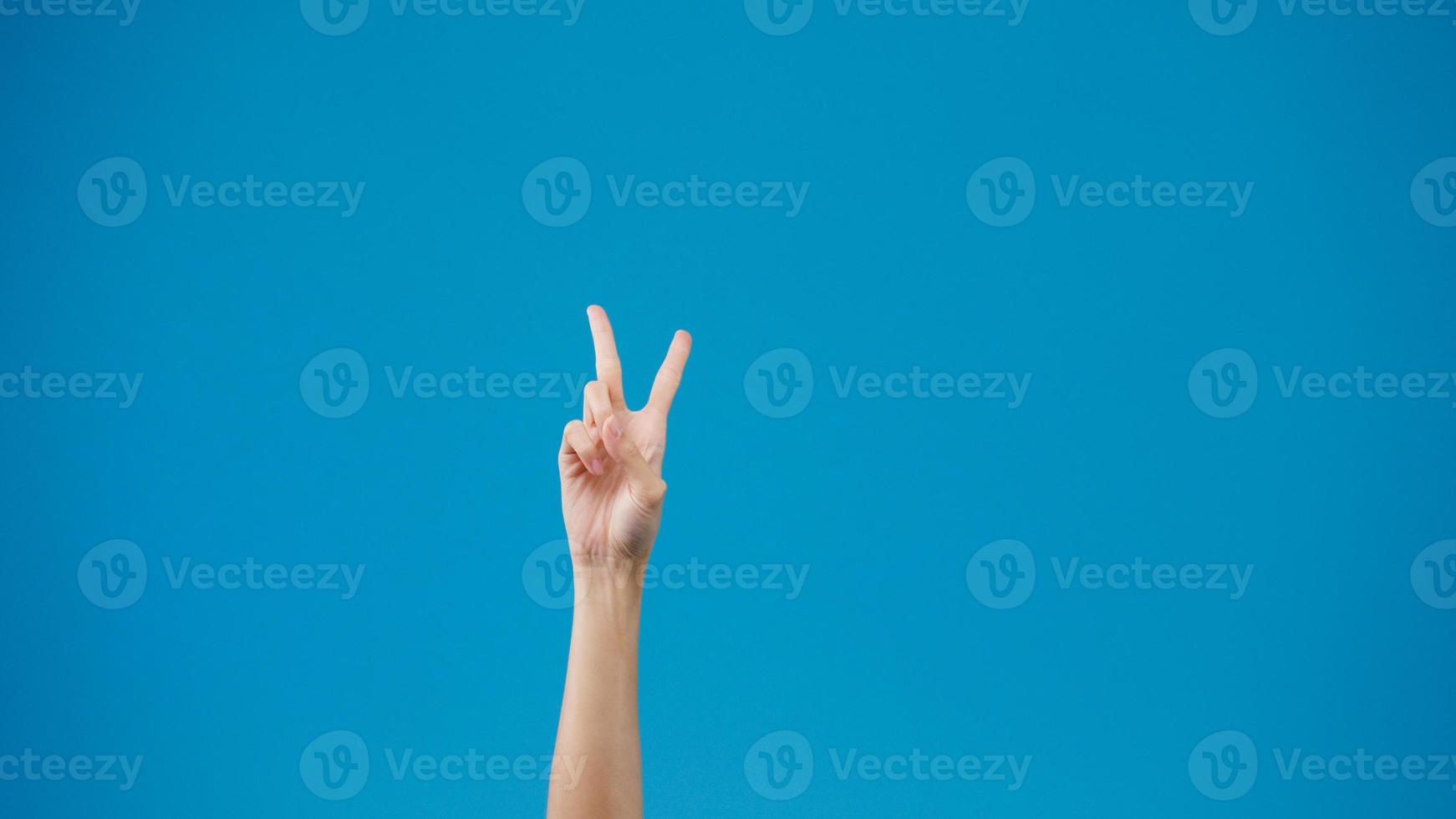 Young woman hand showing thumb up sign with fingers isolated over blue background in studio. Copy space for place a text, message for advertisement. Advertising area, mock up promotional content. photo
