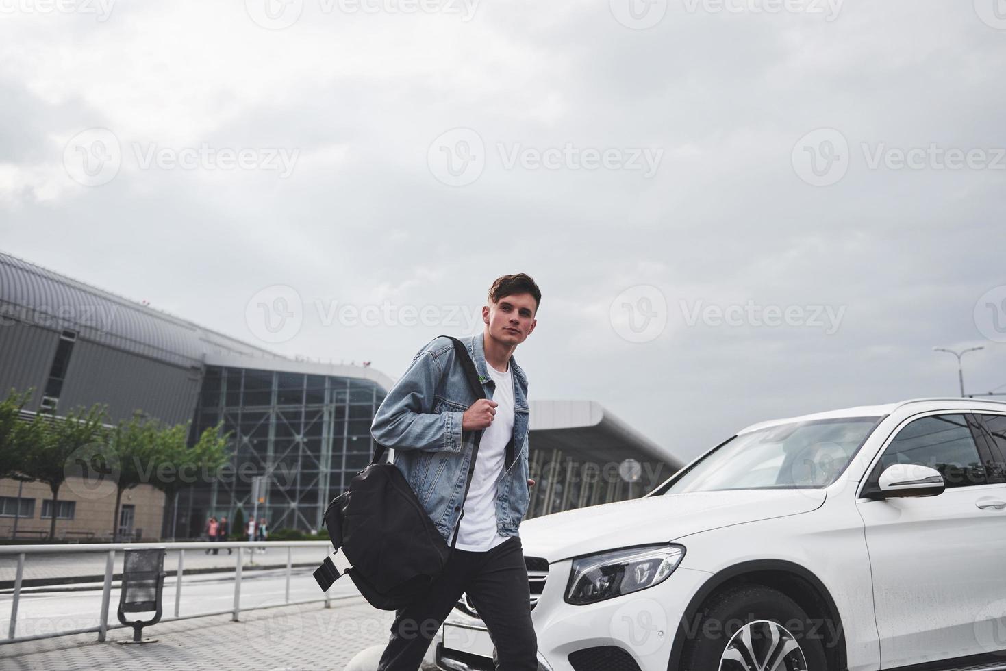 A young beautiful man at the airport is waiting for the flight. photo