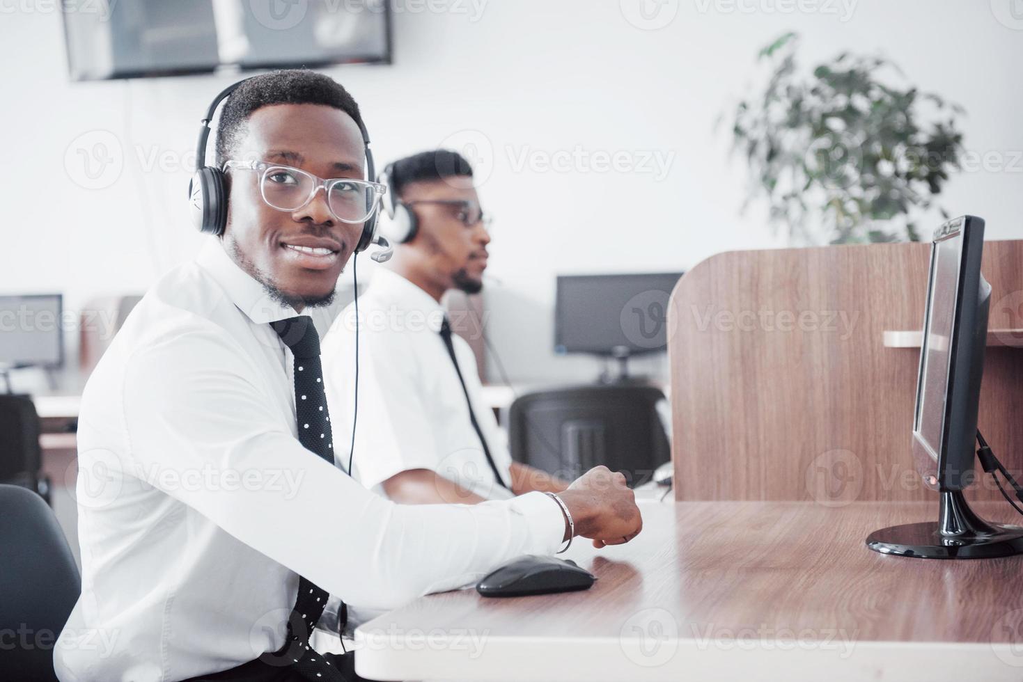 African american customer support operator with hands-free headset working in the office photo