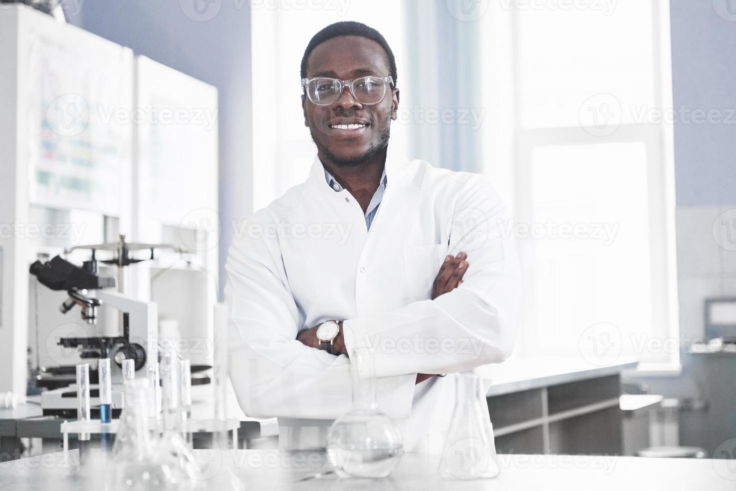 The scientist works with a microscope in a laboratory conducting experiments and formulas. photo