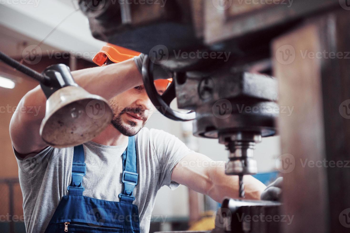 Experienced operator in a hard hat. Metalworking industry concept professional engineer metalworker operating CNC milling machine center in manufacturing workshop photo