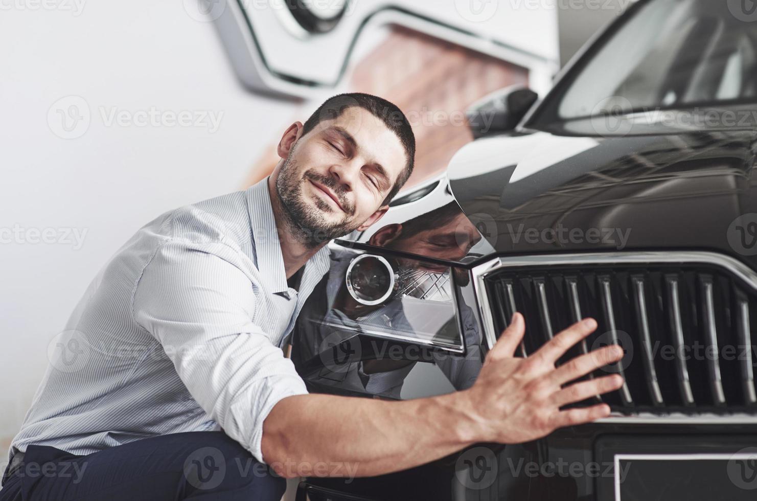 retrato de un hombre sonriente feliz que elige un coche nuevo en la cabina. foto