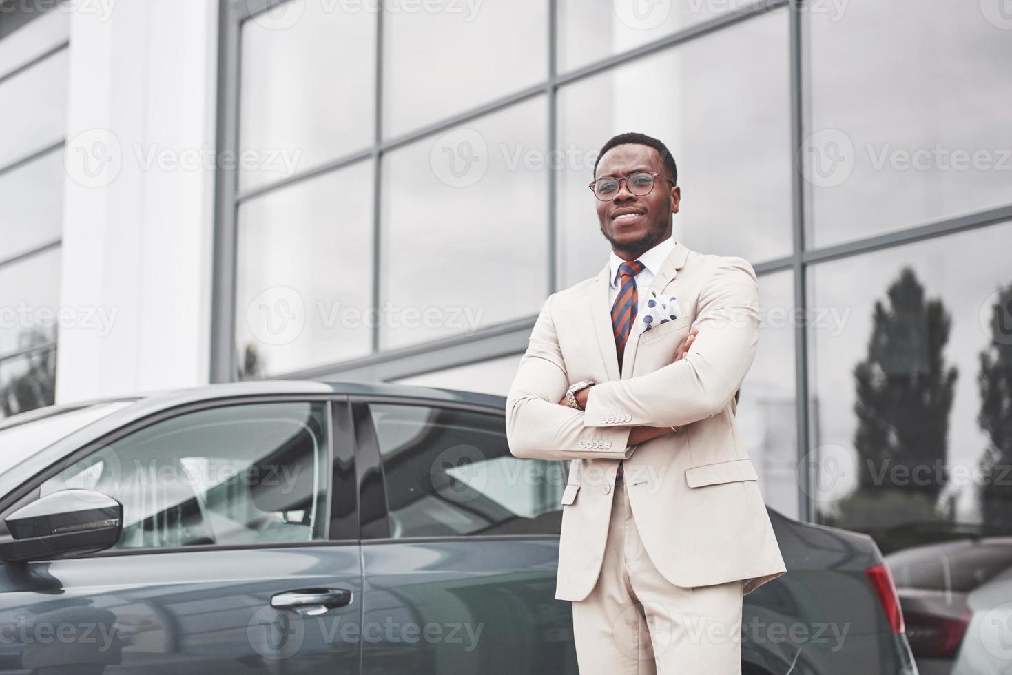 Visiting car dealership. Casual black business man in a suit near the car photo