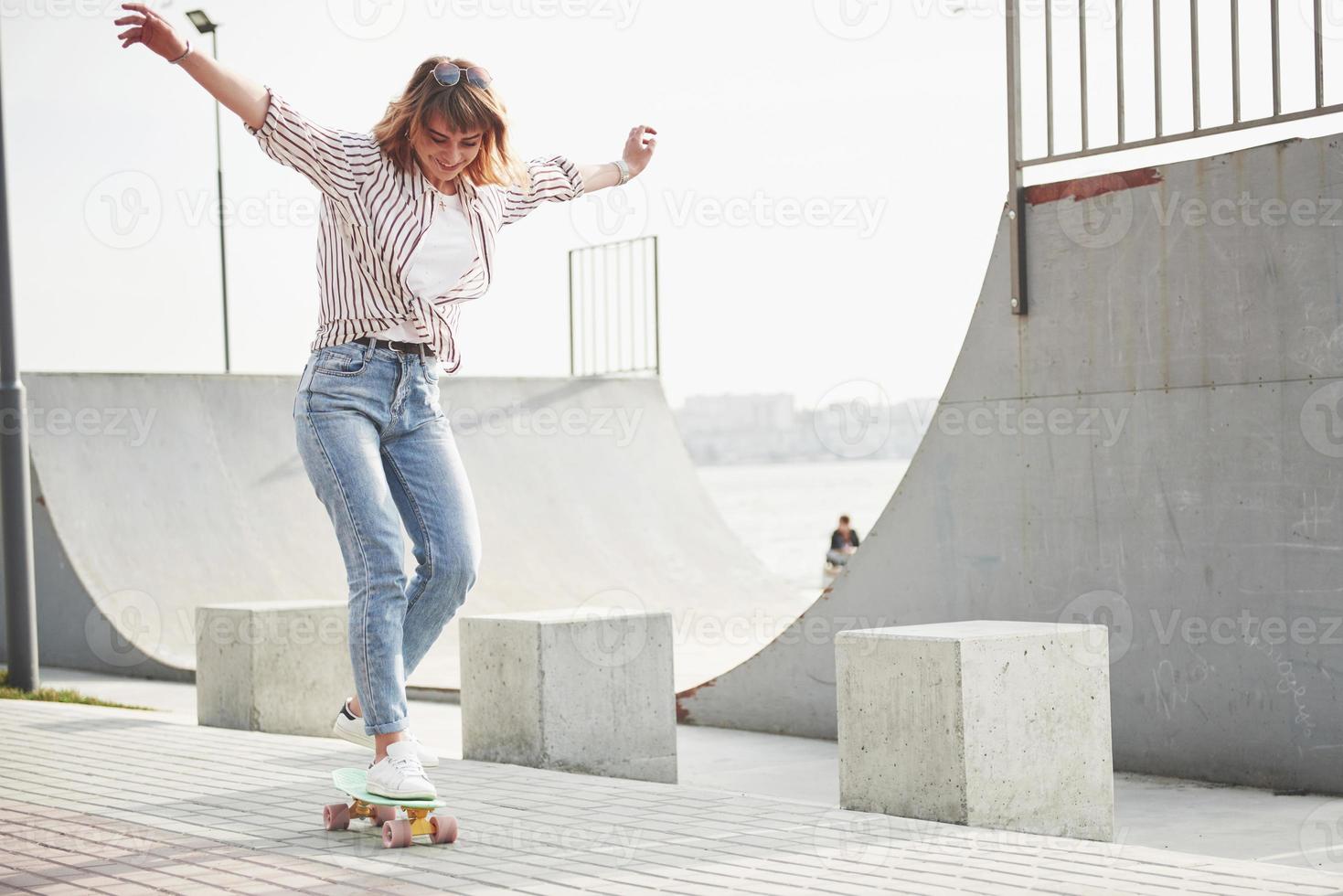 una joven deportista que anda en patineta por un parque. foto