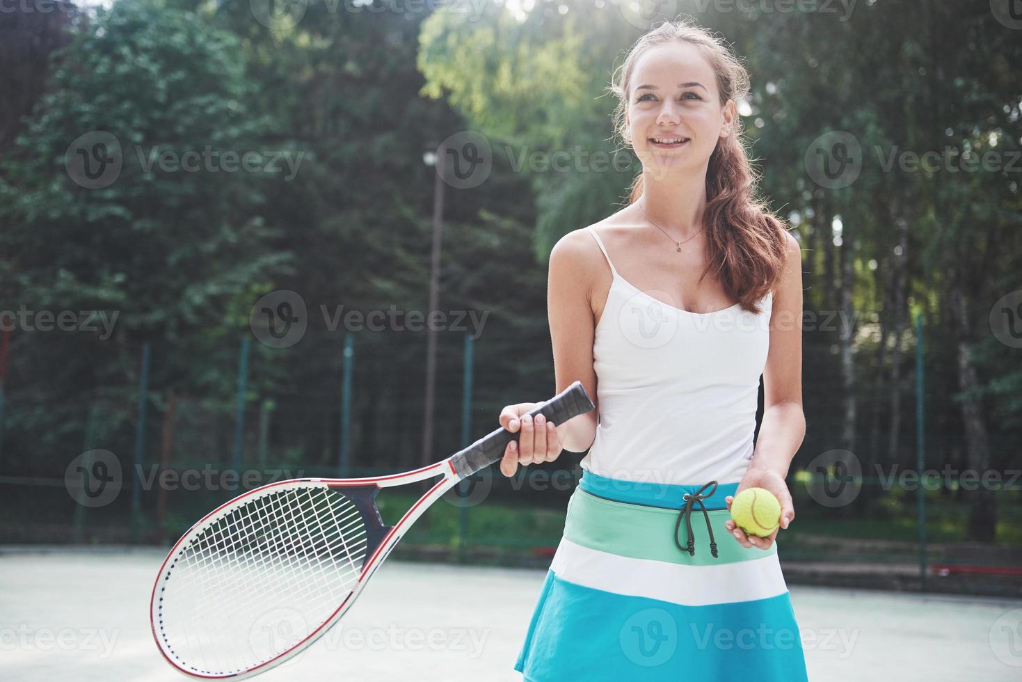 Woman in sportswear serves tennis ball. photo