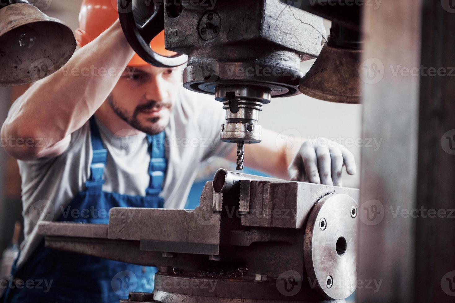 Experienced operator in a hard hat. Metalworking industry concept professional engineer metalworker operating CNC milling machine center in manufacturing workshop photo