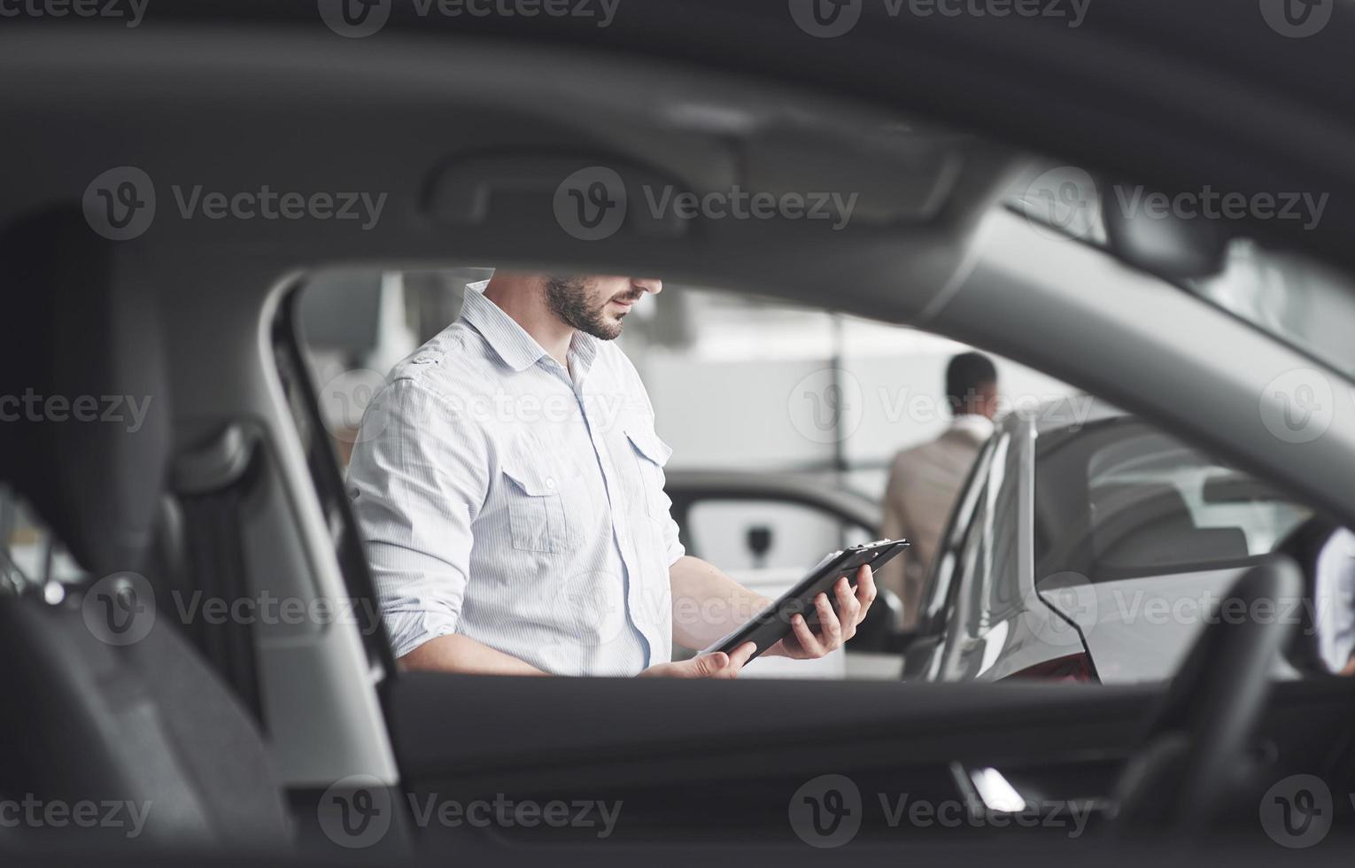 Young sellers with a folder for selling a new car photo