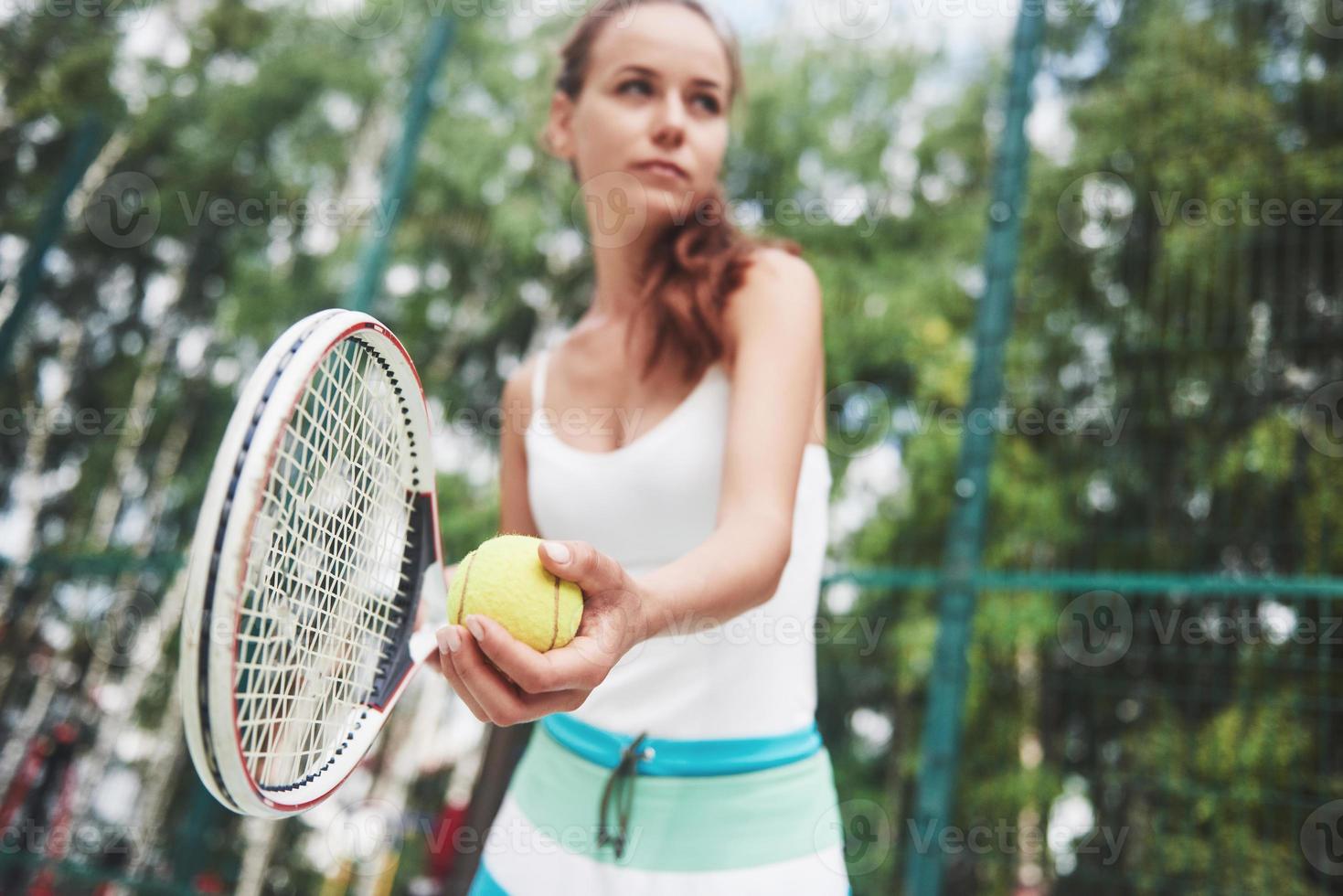 Portrait of a young tennis player standing ready for a serve. photo