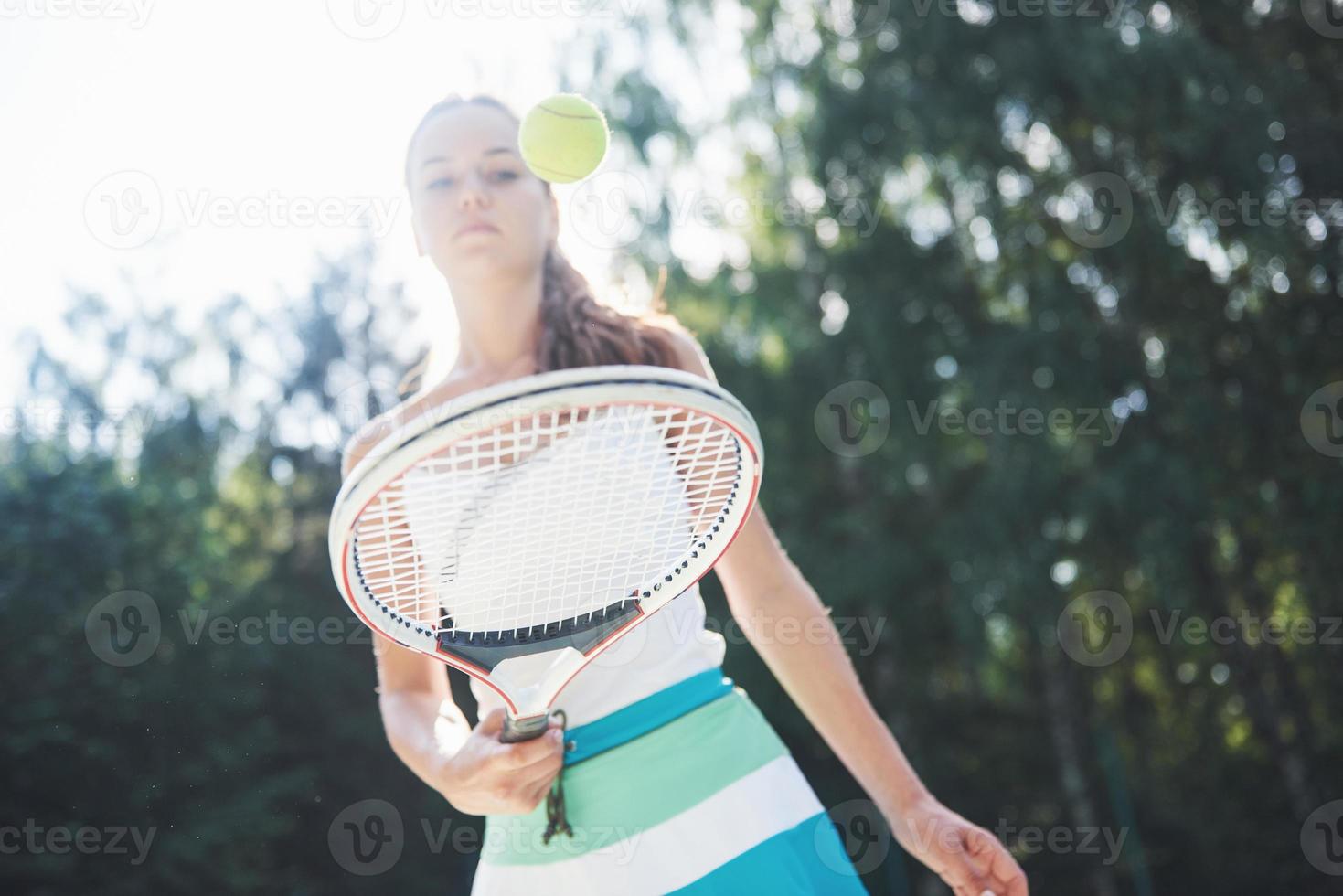 Woman in sportswear serves tennis ball. photo