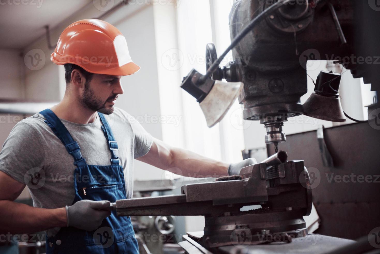 operador experimentado con casco. Concepto de la industria metalmecánica ingeniero profesional obrero metalúrgico operativo fresadora cnc centro en taller de fabricación foto