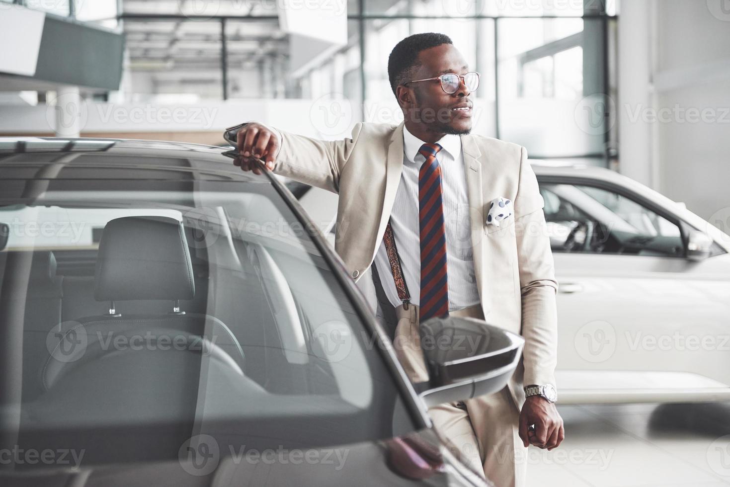 el joven atractivo empresario negro compra un coche nuevo, los sueños se hacen realidad foto