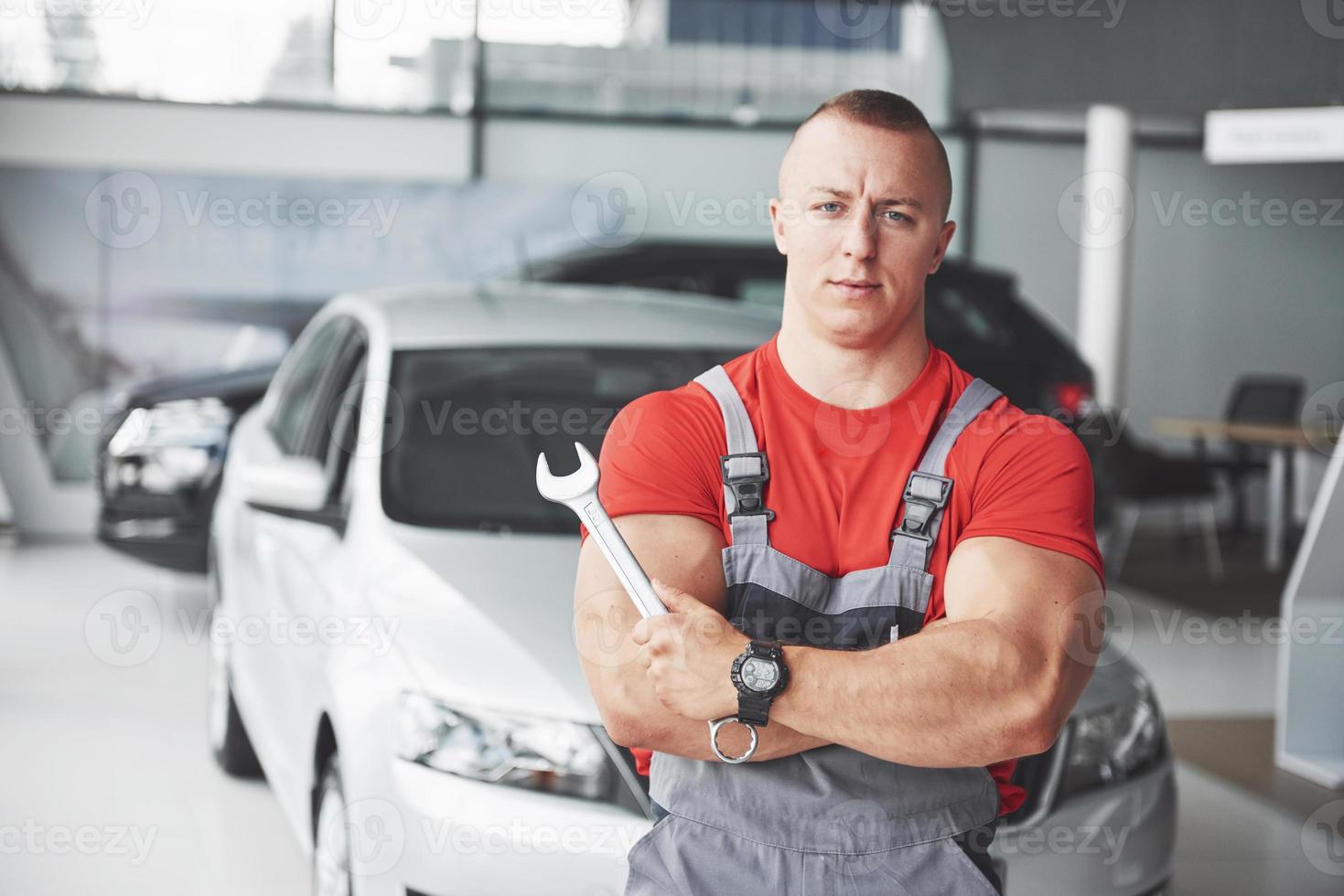 Hands of car mechanic with wrench in garage photo