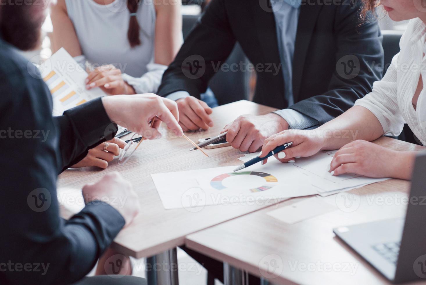 A group of business partners discusses the ideas during an office meeting photo