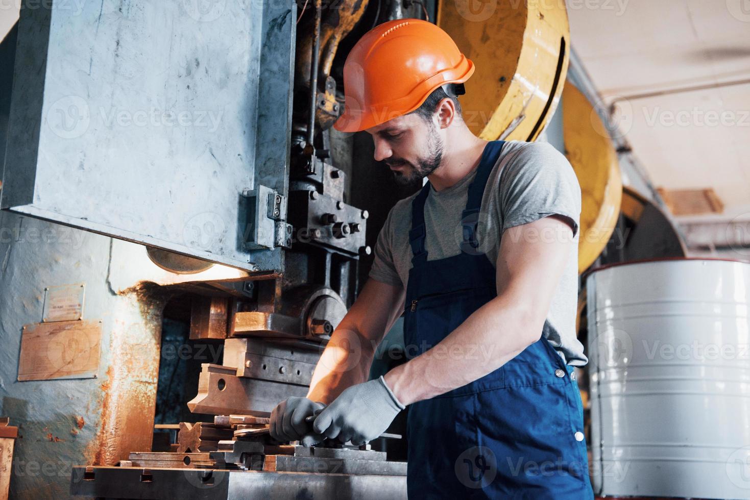 Experienced operator in a hard hat. Metalworking industry concept professional engineer metalworker operating CNC milling machine center in manufacturing workshop photo