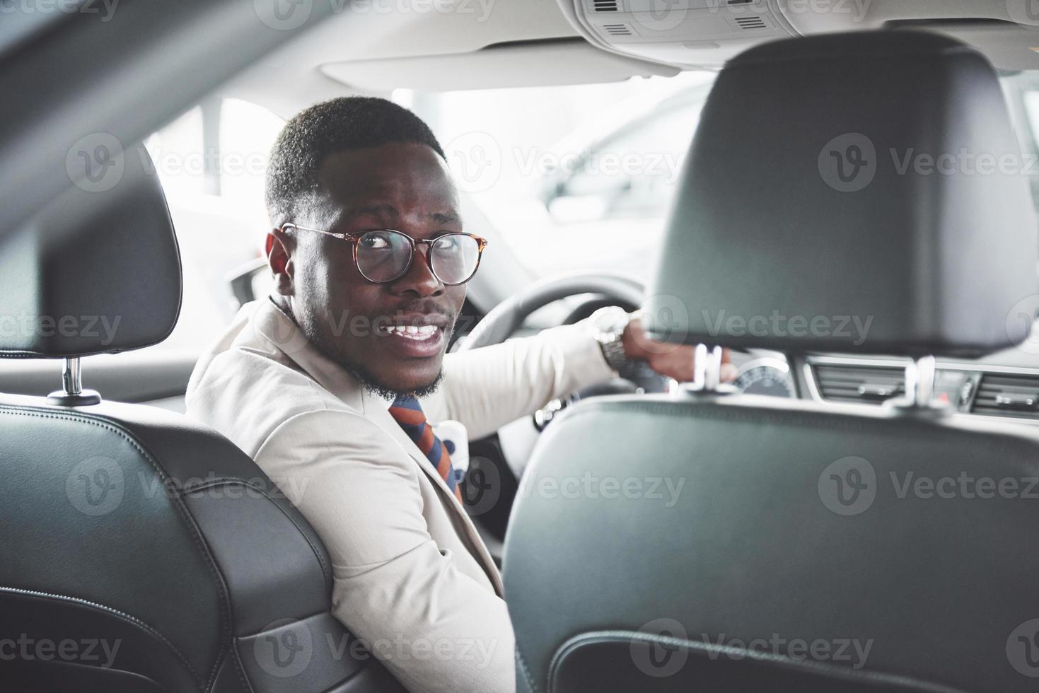 Young black businessman test drive new car. Rich african american man photo