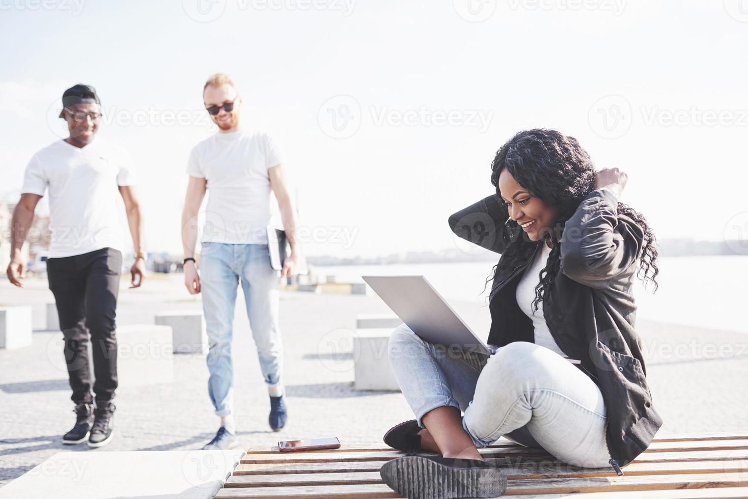 Young woman on the street working on laptop photo