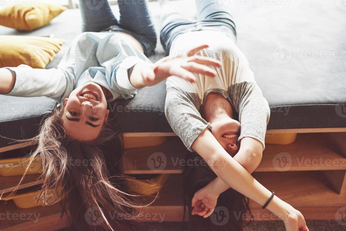 dos hermosas hermanas gemelas jóvenes pasar tiempo juntos con almohadas. hermanos que se divierten en el concepto de casa foto