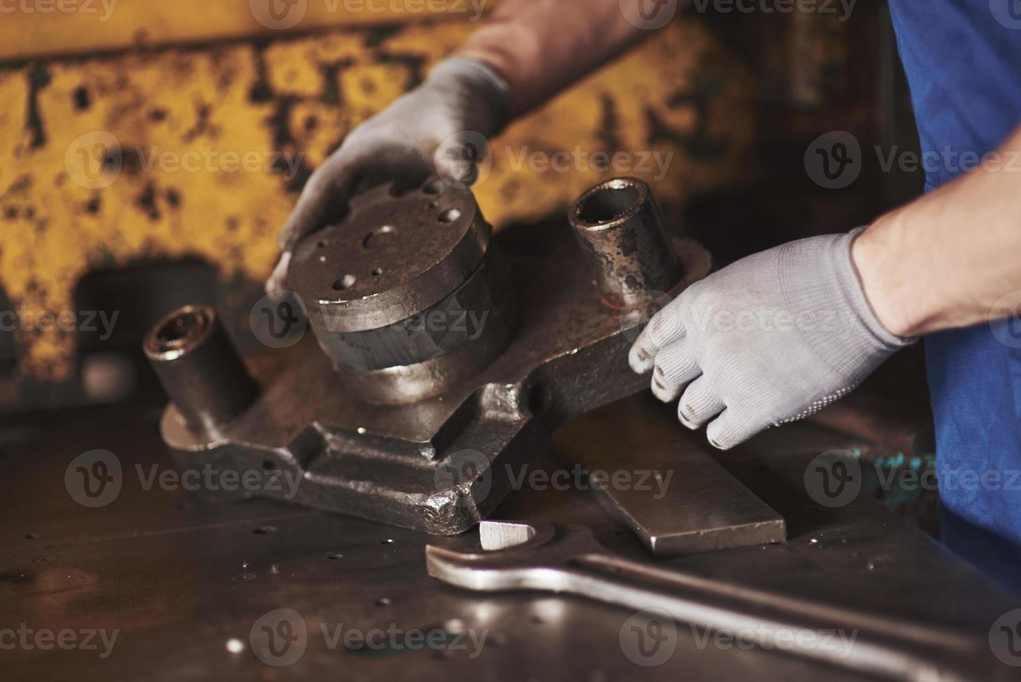 manos fuertes sostienen la pieza de acero. foto