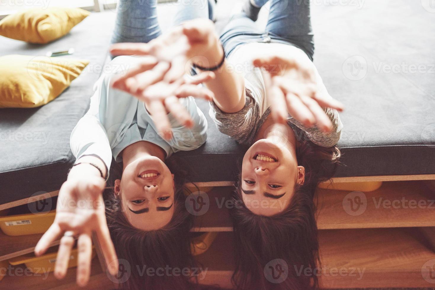 dos hermosas hermanas gemelas jóvenes pasar tiempo juntos con almohadas. hermanos que se divierten en el concepto de casa foto