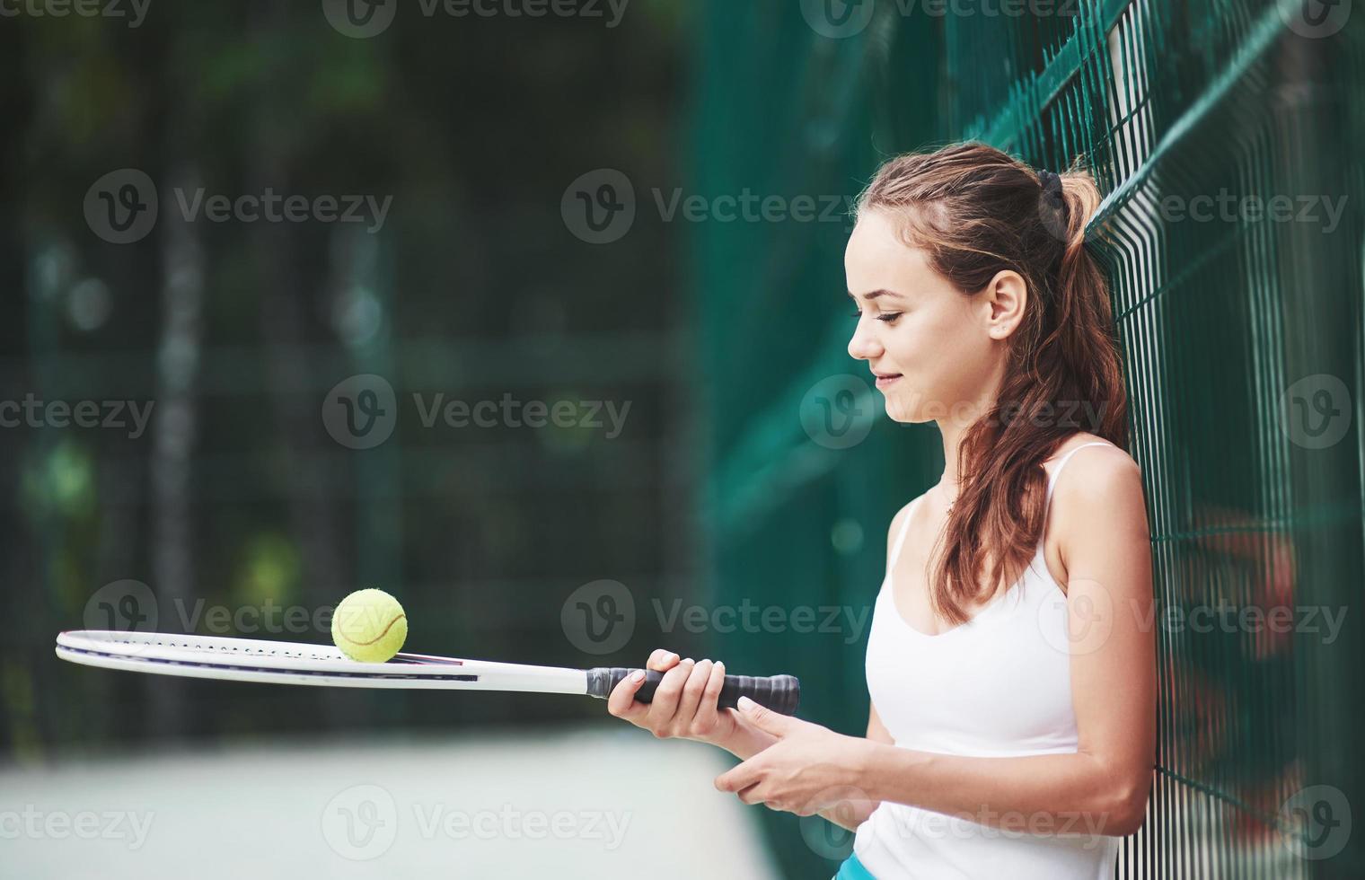 una hermosa mujer con una pelota de tenis de ropa deportiva. foto