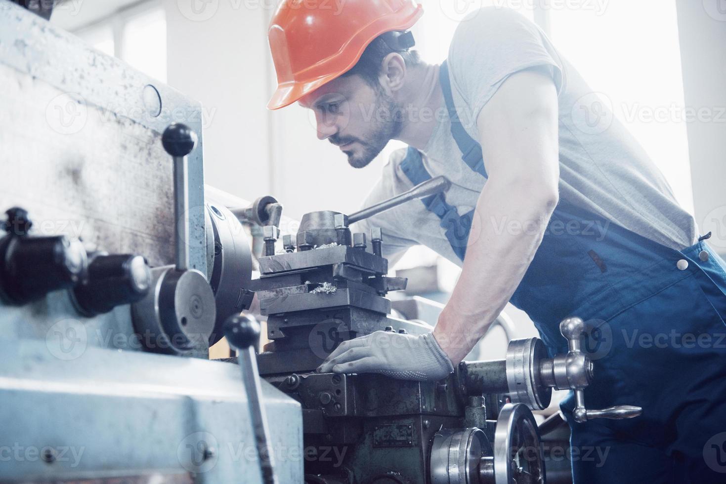 Experienced operator in a hard hat. Metalworking industry concept professional engineer metalworker operating CNC milling machine center in manufacturing workshop photo