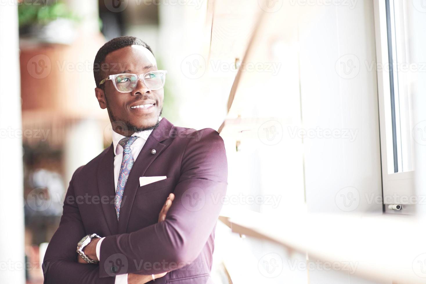 un hermoso empresario afroamericano lee en un café. foto