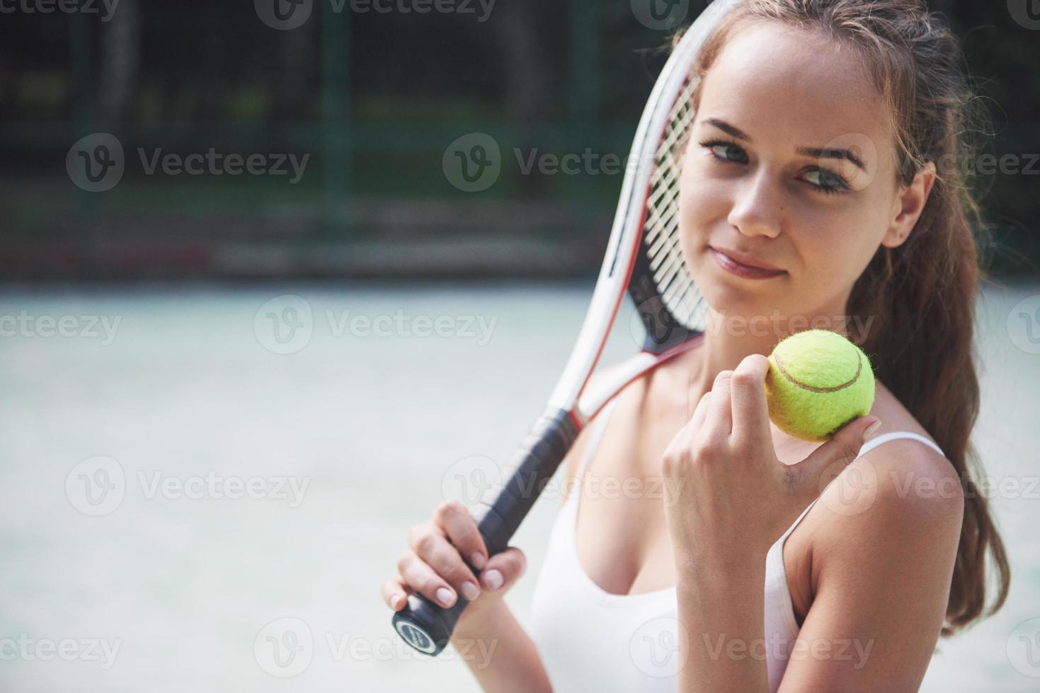 linda chica jugando al tenis y posando para la cámara. foto