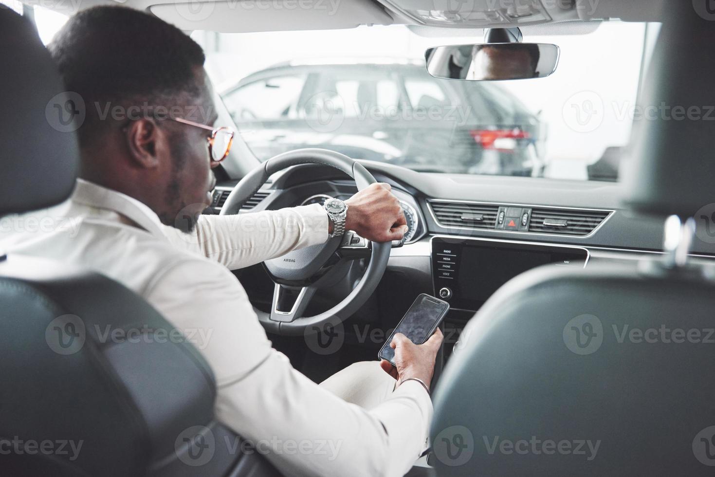 joven empresario negro prueba de conducción coche nuevo. rico hombre afroamericano foto