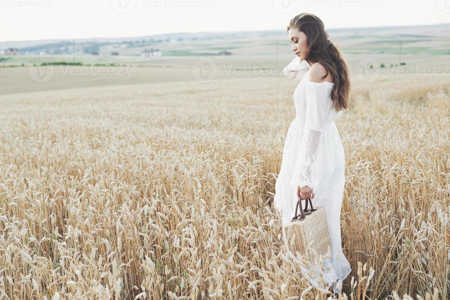 hermosa chica en un campo de trigo con un vestido blanco, una imagen perfecta en el estilo de vida foto