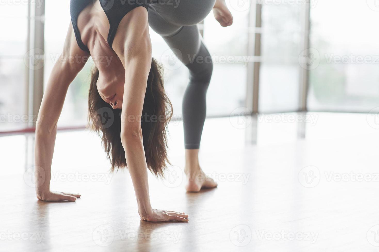 una hermosa mujer de yoga practicando en un amplio gimnasio ligero foto