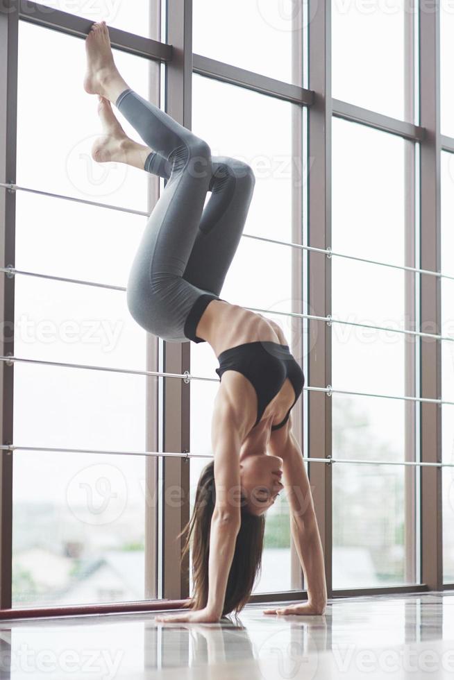 una hermosa mujer de yoga practicando en un amplio gimnasio ligero foto