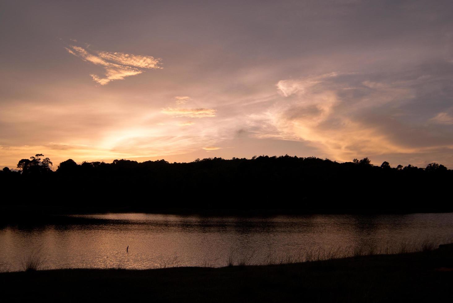 hermoso cielo paisaje con puesta de sol sobre la orilla del río foto