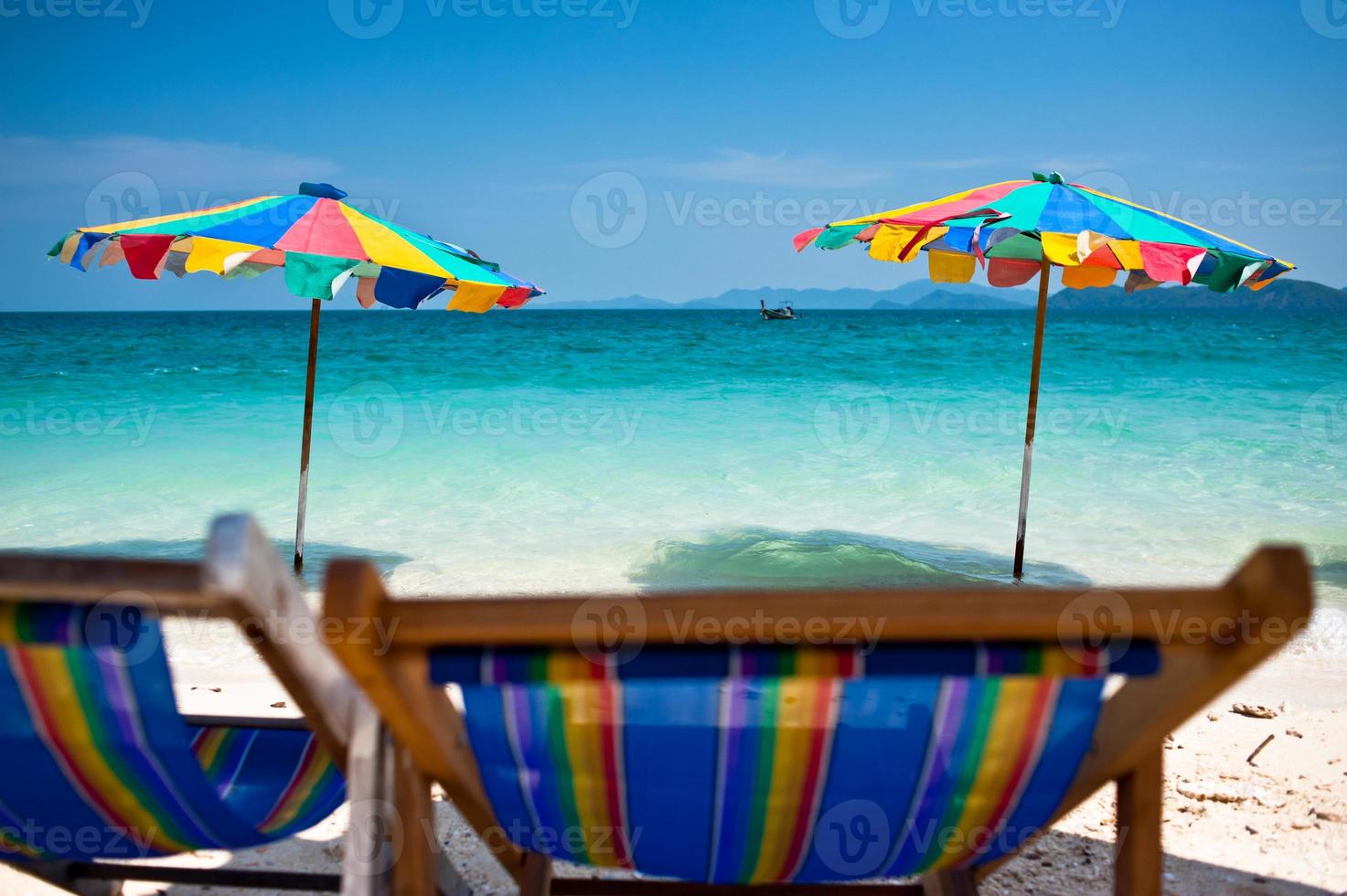 Silla de playa bajo la sombrilla de colorido en la playa de Phuket, Tailandia foto