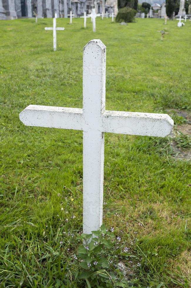 Old white cross in cemetery photo