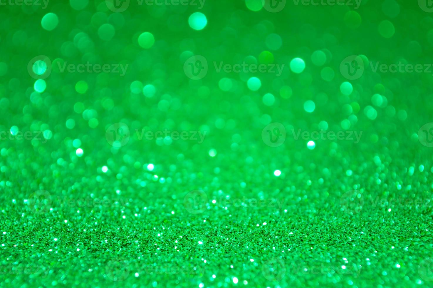 Green abstract glitter background with defocused lights photo