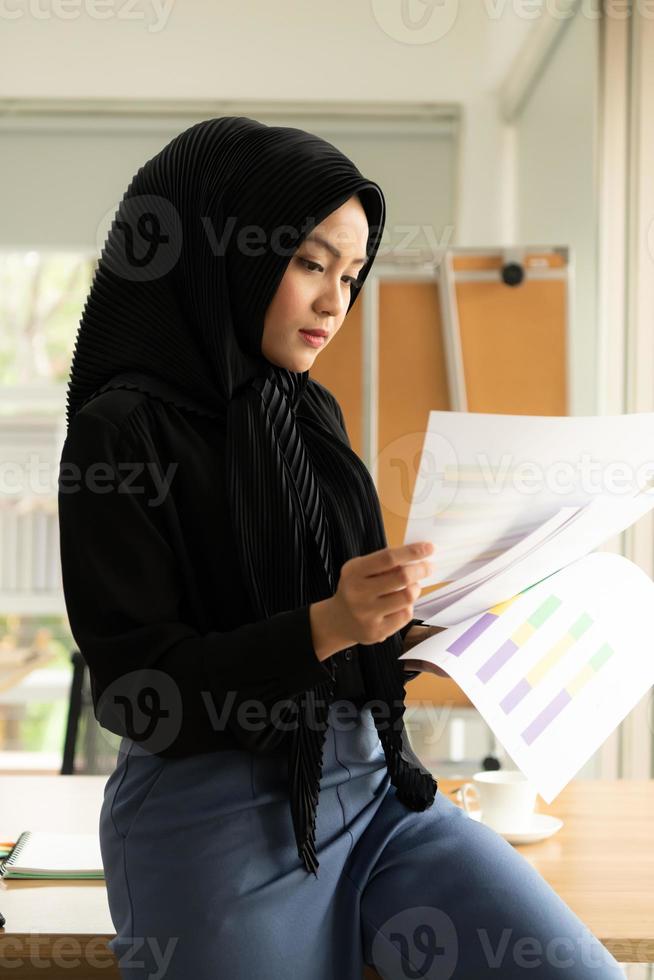 La empresaria árabe vistiendo hijab trabaja en la oficina. foto