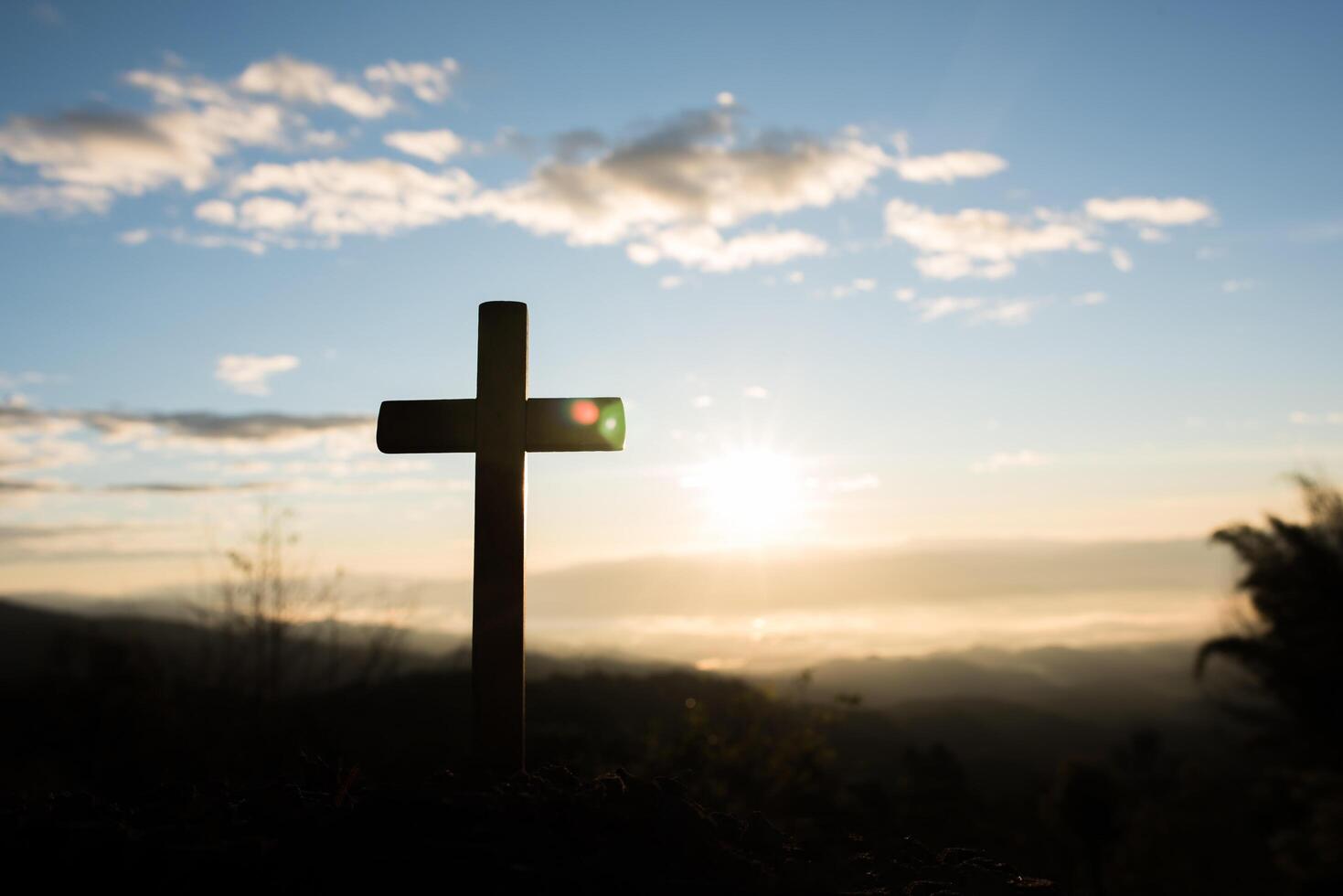 Silhouette of catholic cross and sunrise photo